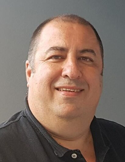 Martín Salvetti en un estudio de radio escolar, frente al micrófono, rodeado de alumnos.